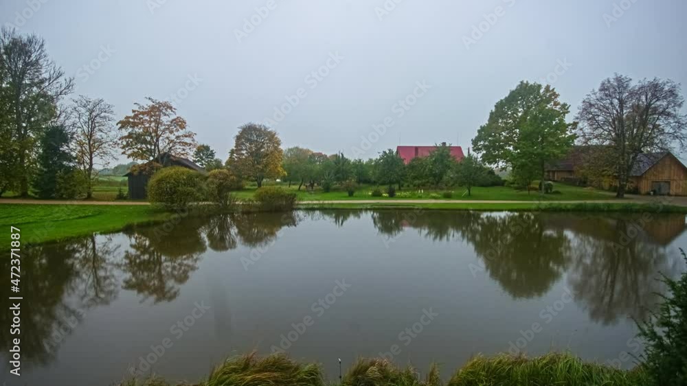 Full day moody timelapse at a lake with luxury cabins background in countryside Full day moody timelapse at a lake with luxury cabins background in countryside