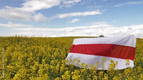 Woman with Belarus flag in yellow rapeseed field photo