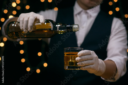 Barman pouring whiskey whiskey glass beautiful night