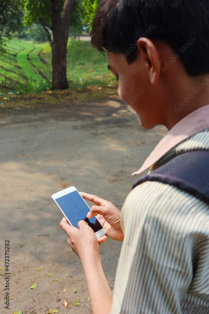 Indian school boy using smartphone screen. online education concept. Indian school boy using smartphone screen. online education concept.