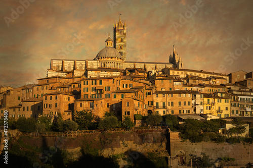 The cathedral of Siena, a city in Tuscany, Italy, bathed in warm sunset glow.