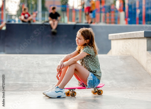Girl with skateboard outdoors