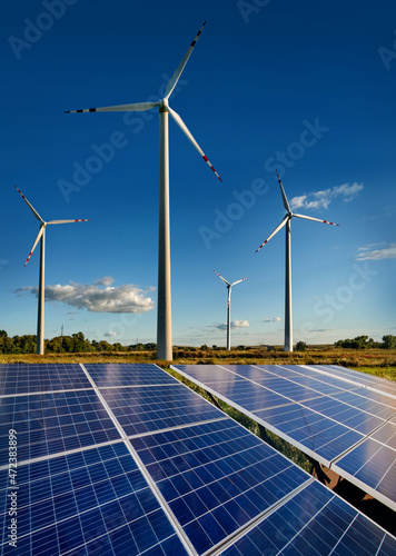 Wind turbines and solar panels closeup on sky background