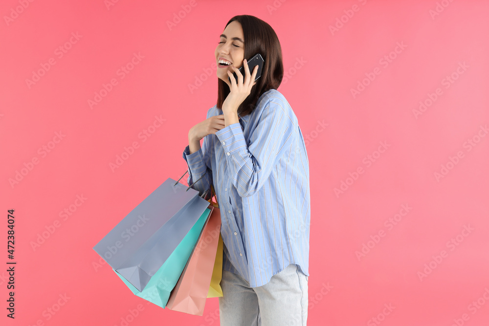 Attractive woman with shop bags on pink background Attractive woman with shop bags on pink background