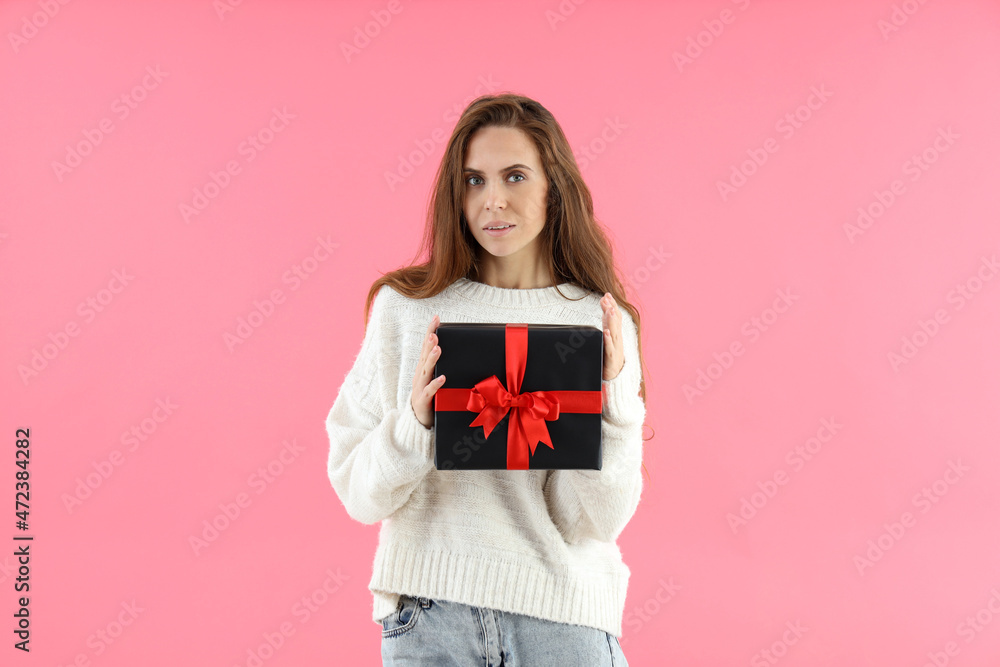 Attractive woman holds gift box on pink background Attractive woman holds gift box on pink background