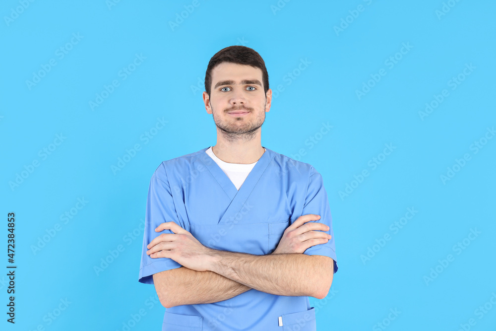 Young attractive male nurse on blue background