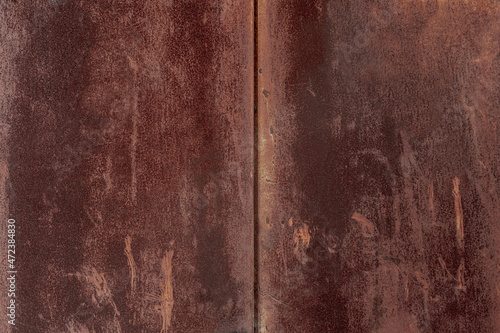 Texture of old rusty grungy metal sheet. Uneven aged rough bumpy surface. Corrugated painted wall of smudged iron. Rusted hard pitted retro garage door. Vintage dirty destroyed roof for grunge design