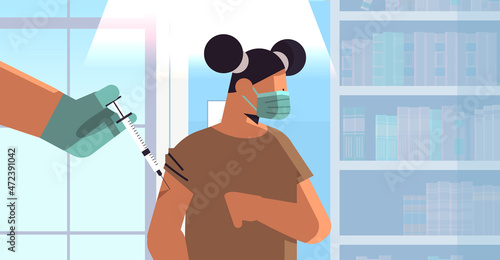 doctor hand vaccinating girl patient in medical mask fight against coronavirus vaccine development concept
