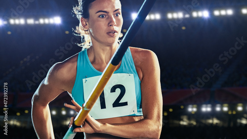 Tableau sur toile Pole Vault Jumping: Portrait of Professional Female Athlete on World Championship Running with Pole to Jump over Bar