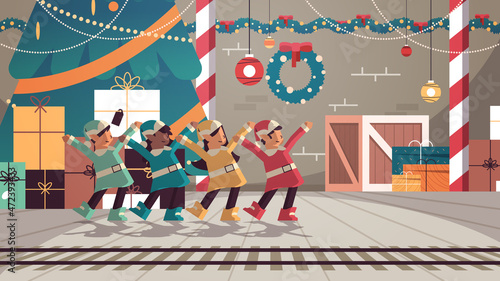 mix race elves in uniform having fun santa helpers team celebrating happy new year merry christmas holidays