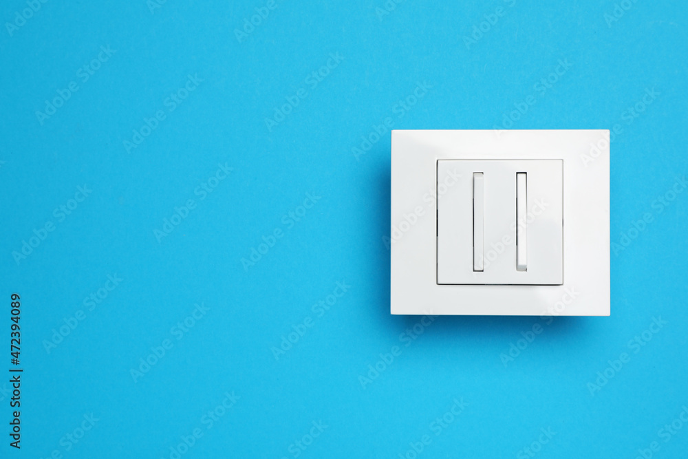 White light switch on light blue background, top view. Space for text White light switch on light blue background, top view. Space for text