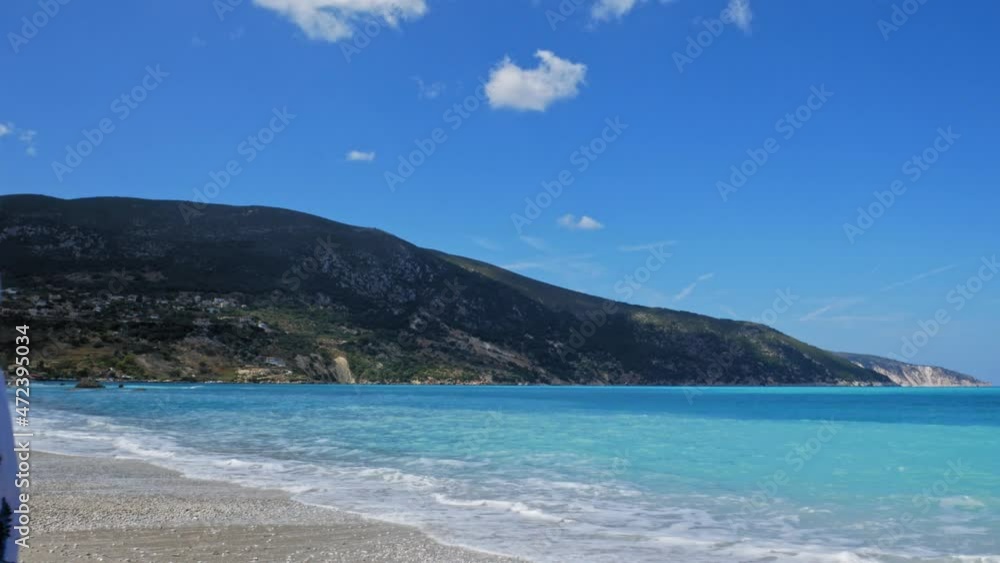 Charming Woman With Smartphone In Hand Walking Away From The Shore Smiling In Agia Kiriaki Beach, Zola In Kefalonia, Greece. - Medium Shot Charming Woman With Smartphone In Hand Walking Away From The Shore Smiling In Agia Kiriaki Beach, Zola In Kefalonia, Greece. - Medium Shot