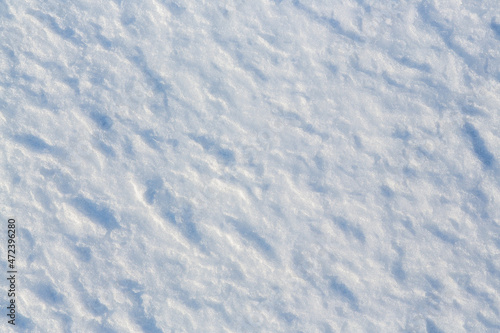Natural snow texture. The surface of the snow crust. Snowy ground. Winter background with snow patterns. Perfect for Christmas and New Year design. Closeup top view. © Andrei Stepanov