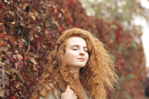 portrait of young woman on the background of autumn leaves