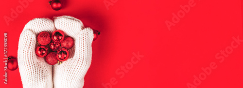 Red balls lie in women's hands in white mittens. photo