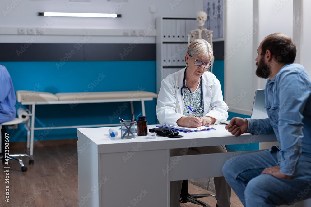 Obraz premium Woman doctor signing checkup files to give treatment to man after examination. Physician writing prescription medicine and signature on papers to help patient at medical appointment.