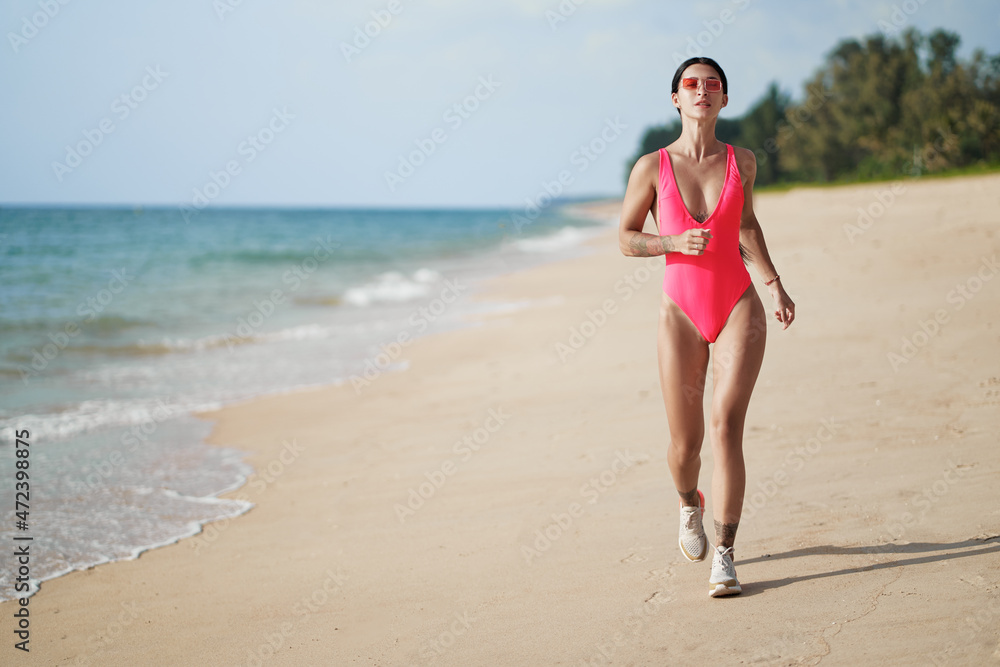 Healthy lifestyle. Jogging outdoors. Young woman exercising on sea beach.