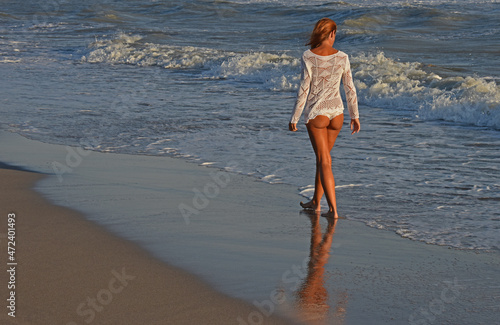 woman walking on the beach in white mesh top and white thong panties photo