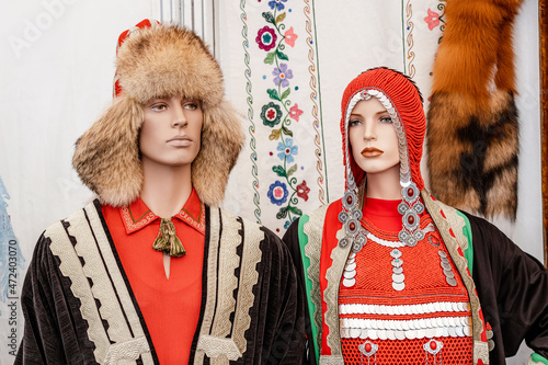 Traditional Bashkir national costumes with monists made of ancient coins and bright red fabric on a mannequin photo