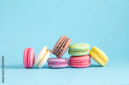 Colorful cake macaron or macaroon on pastel blue background. Sweet background. Flat lay, top view, copy space