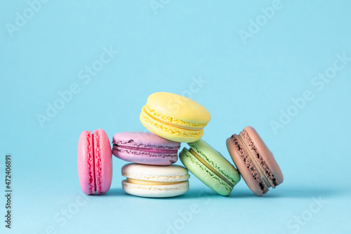 Fototapeta Colorful cake macaron or macaroon on pastel blue background