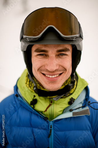Head shot of smiling man skier wearing ski helmet with goggles © fesenko