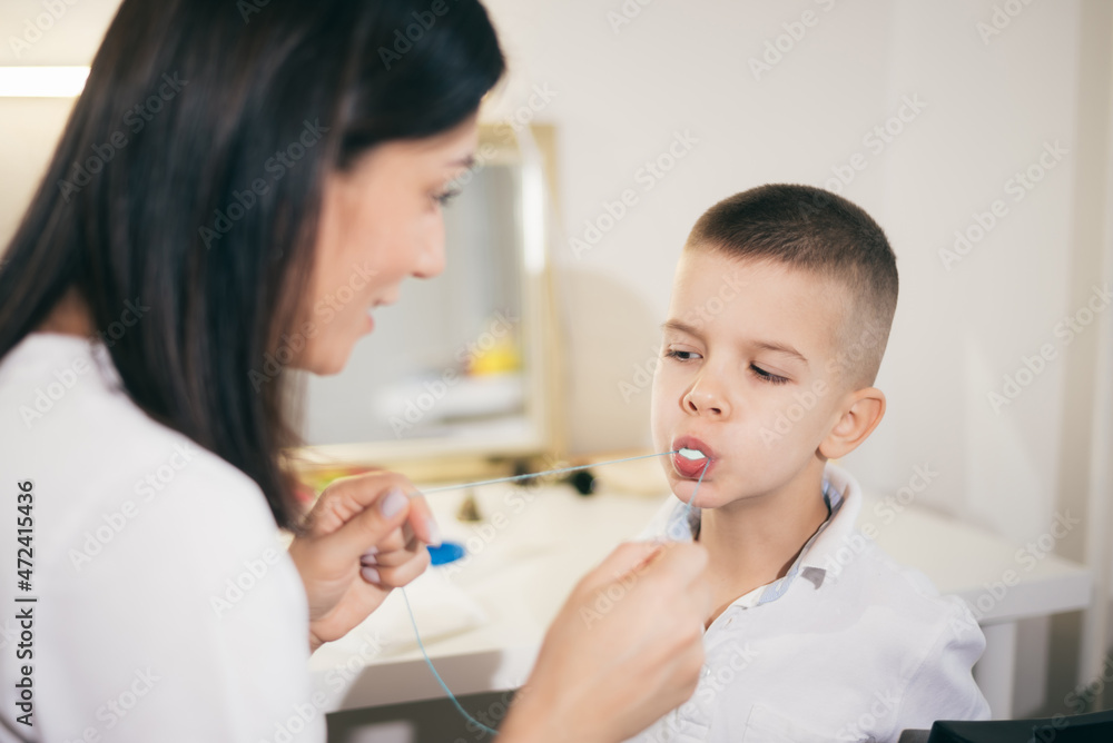 Woman speech therapist helps a boy correct the violation of his speech Woman speech therapist helps a boy correct the violation of his speech