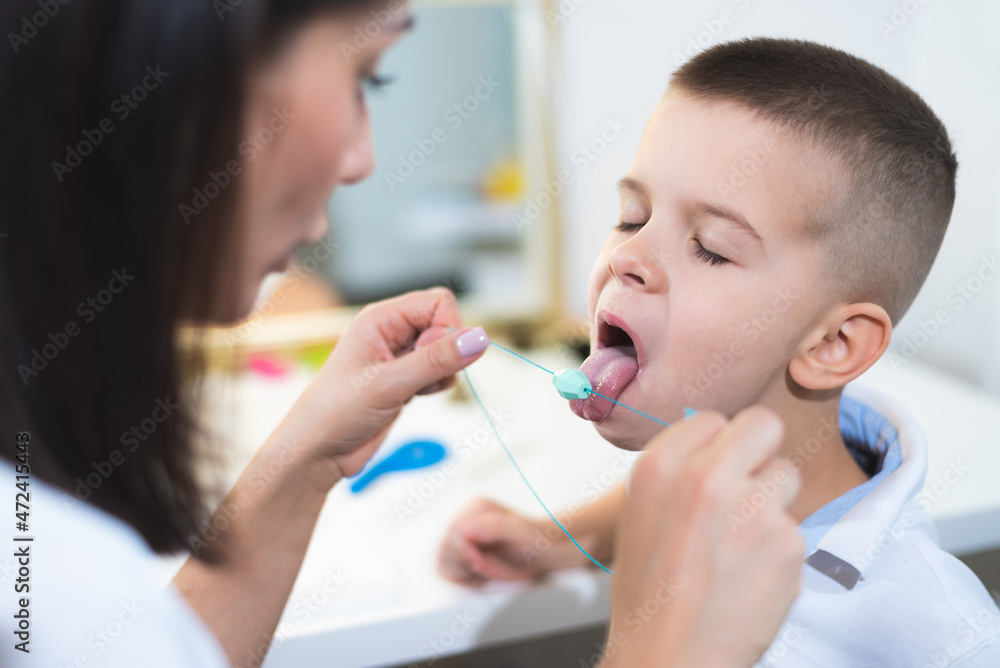 Woman speech therapist helps a boy correct the violation of his speech Woman speech therapist helps a boy correct the violation of his speech