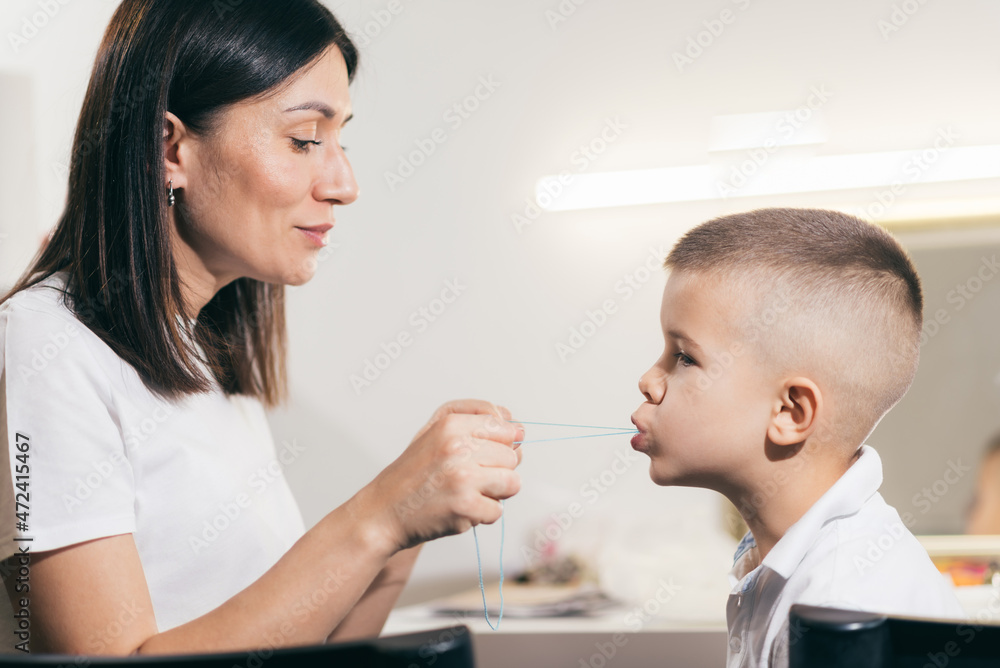 Woman speech therapist helps a boy correct the violation of his speech Woman speech therapist helps a boy correct the violation of his speech