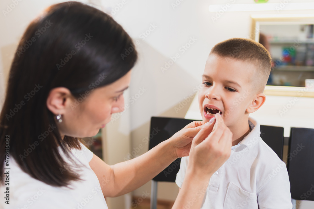Woman speech therapist helps a child correct the violation of his speech in her office Woman speech therapist helps a child correct the violation of his speech in her office