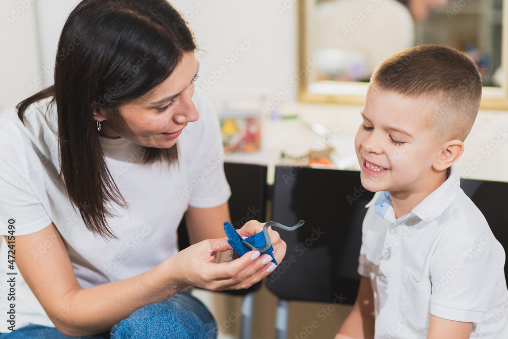 Woman speech therapist helps a child correct the violation of his speech in her office Woman speech therapist helps a child correct the violation of his speech in her office