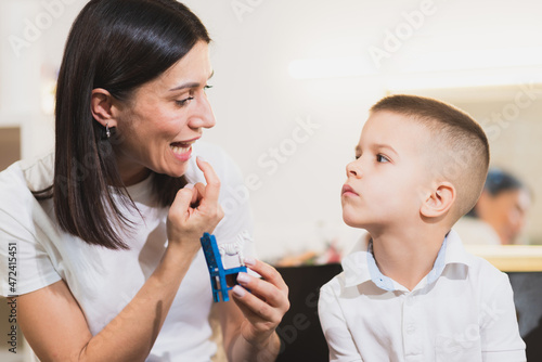 A woman speech therapist deals with the child and teaches him the correct pronunciation and competent speech.