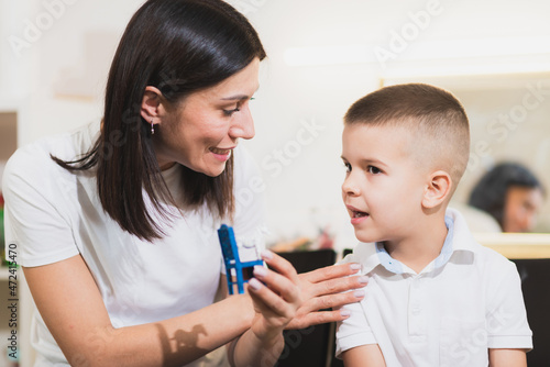A woman speech therapist deals with the child and teaches him the correct pronunciation and competent speech.