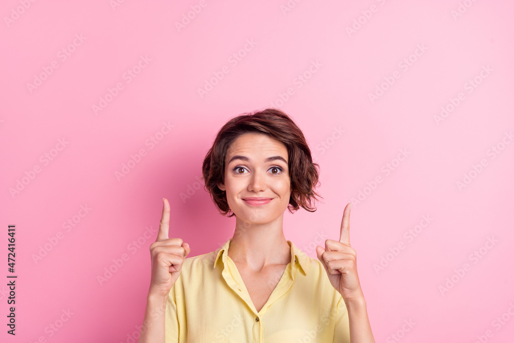 Photo of cool millennial brunette lady point empty space wear yellow t-shirt isolated on pink color background
