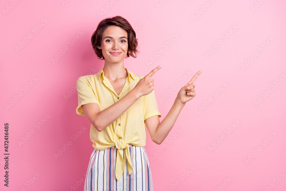 Photo of lovely young brunette lady point empty space wear yellow t-shirt isolated on pink color background Photo of lovely young brunette lady point empty space wear yellow t-shirt isolated on pink color background