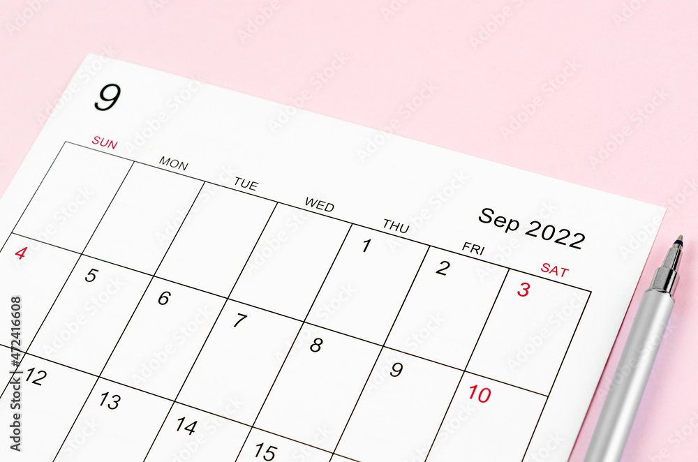 September 2022 calendar sheet with pen on pink September 2022 calendar sheet with pen on pink