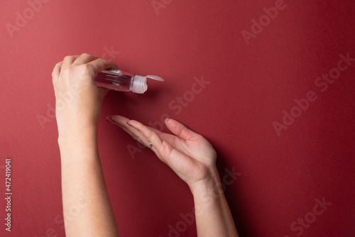 Female hands using alcohol gel on fingers