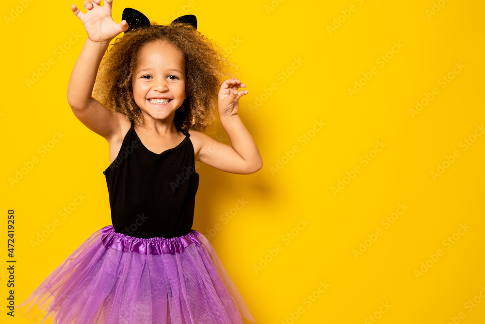 Little girl posing in a halloween costume isolated over yellow background. Little girl posing in a halloween costume isolated over yellow background.