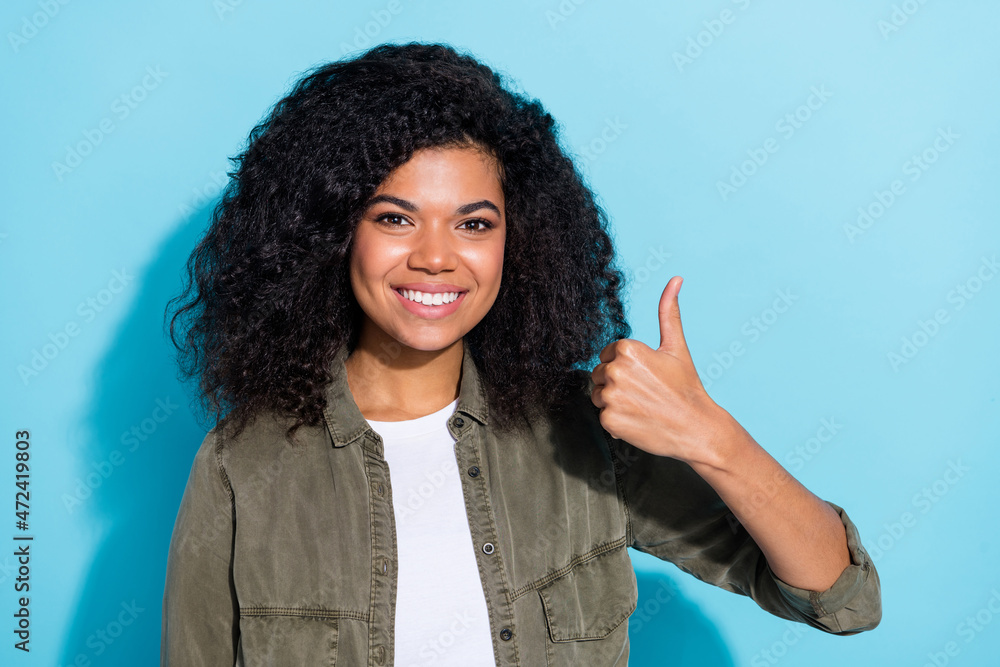 Photo of young cheeerful african woman show thumb-up ad promo choice suggest isolated over blue color background Photo of young cheeerful african woman show thumb-up ad promo choice suggest isolated over blue color background
