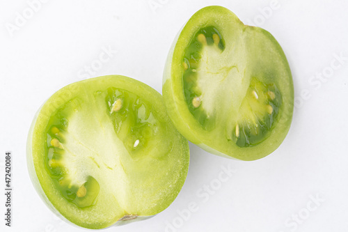 sliced green tomato on white background