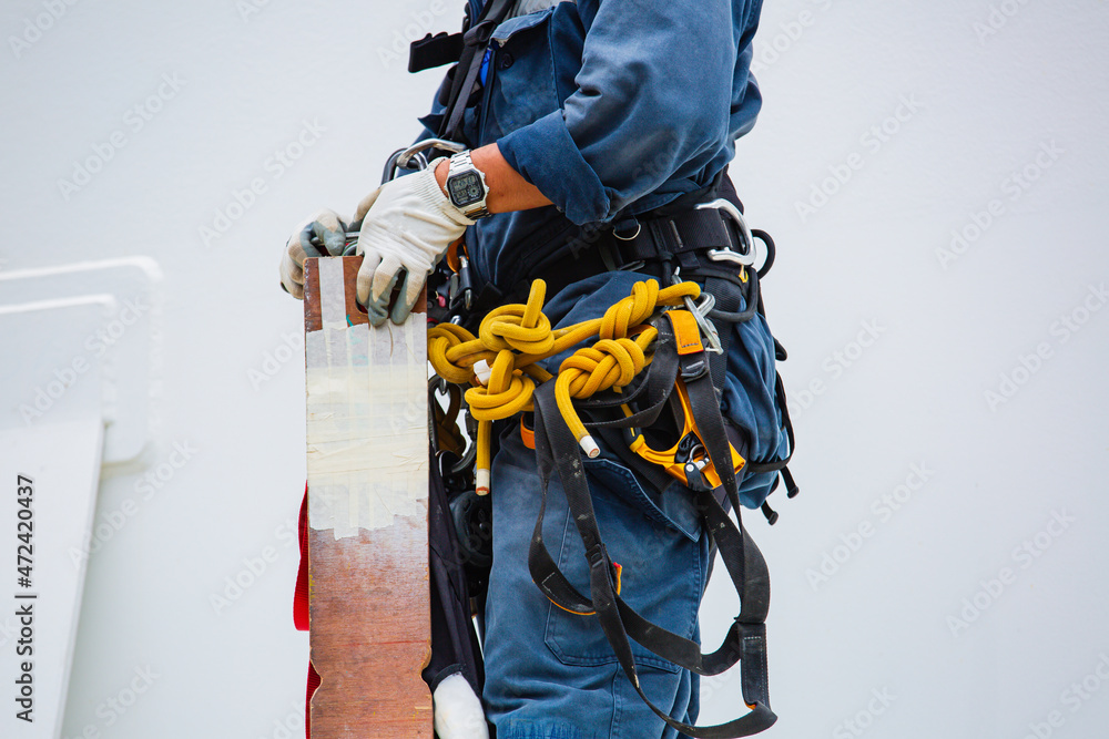 Closeup male worker standing on tank male worker height roof tank knot carabiner rope. Closeup male worker standing on tank male worker height roof tank knot carabiner rope.