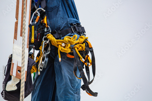 Closeup male worker standing on tank male worker height roof tank knot carabiner rope.