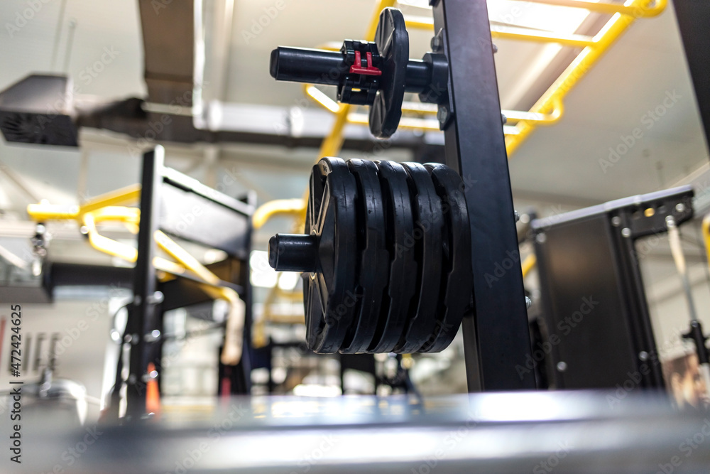Cropped shot of a heavy dumbbells and exercise equipment. Close up of a health exercise equipment for bodybuilding in modern fitness center gym room.