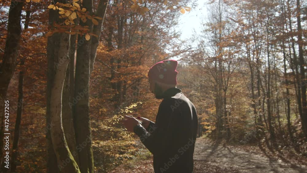 One confident mid adult man standing on dirt road, looking into map for directions, sunny autumn day. Rear view shot. Copy space. One confident mid adult man standing on dirt road, looking into map for directions, sunny autumn day. Rear view shot. Copy space.