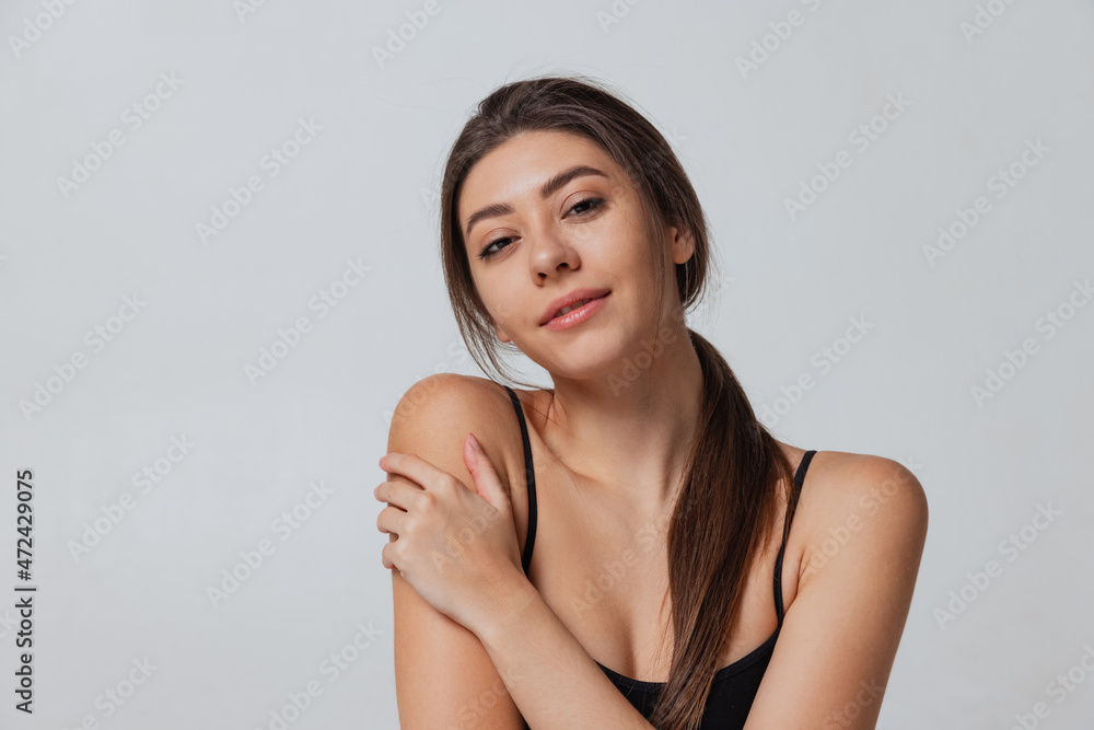 Young adorable girl looking at camera isolated over gray studio background. Natural beauty concept. Young adorable girl looking at camera isolated over gray studio background. Natural beauty concept.