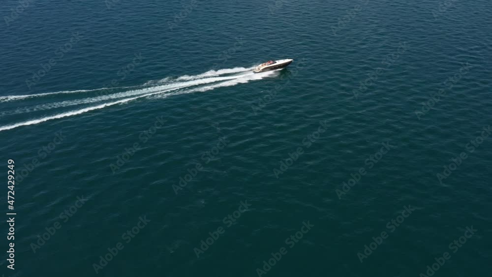 Luxurious big boat fast diagonal movement on blue water, aerial view. Expensive, luxury, high-speed boat moving on the water top view. White boat movement on the water top view. Luxurious big boat fast diagonal movement on blue water, aerial view. Expensive, luxury, high-speed boat moving on the water top view. White boat movement on the water top view.