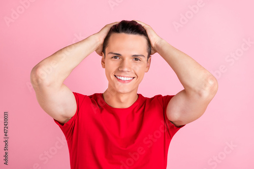Photo of attractive adorable young guy dressed red t-shirt hands arms head smiling isolated pink color background © deagreez