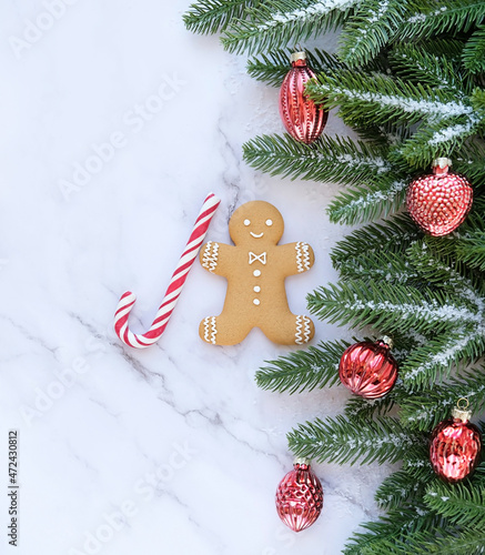 Christmas and New Year holidays concept. christmas decor, gingerbread man and candy cane, fir tree on marble background. festive winter season symbol. flat lay. copy space