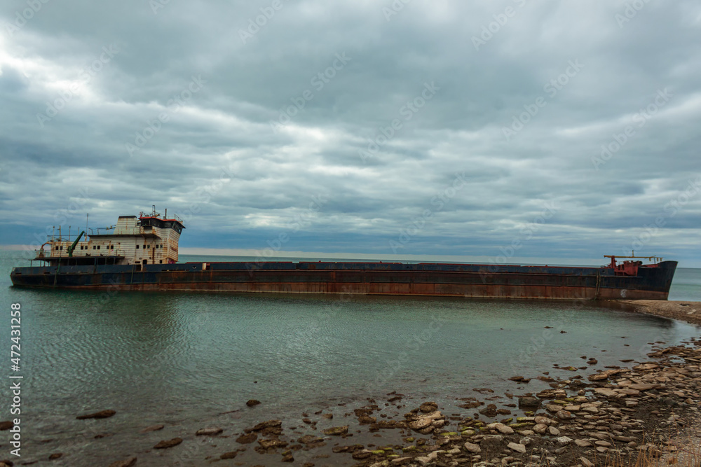 Shipwreck of a dry cargo ship off the coast of the Taman Peninsula. An abandoned rusty vessel on the shoal in the black sea. Shipwreck of a dry cargo ship off the coast of the Taman Peninsula. An abandoned rusty vessel on the shoal in the black sea.