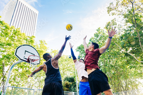 Group of friends jumping and tossing ball up photo